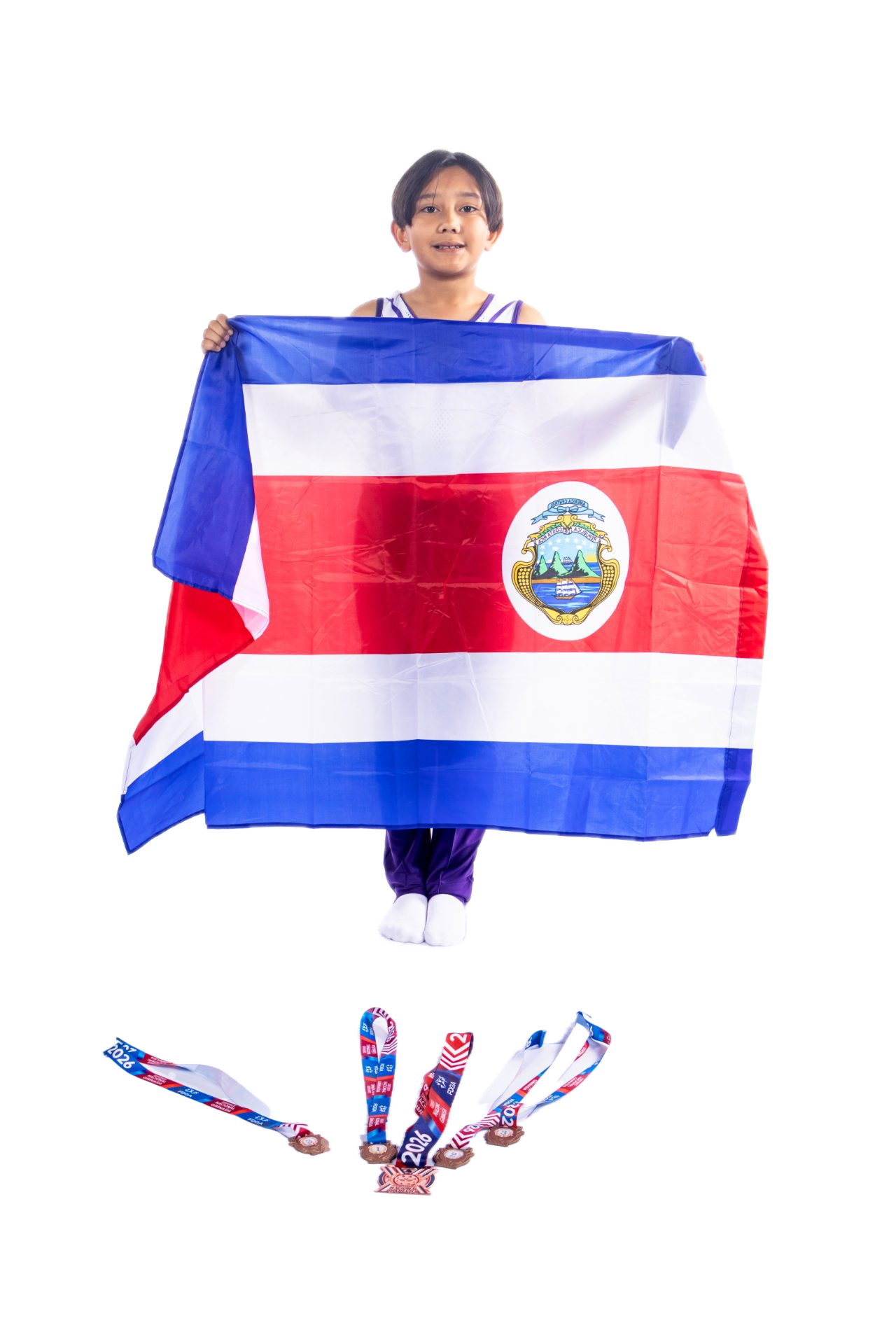 Joven gimnasta sosteniendo la bandera de Costa Rica, con medallas en el suelo